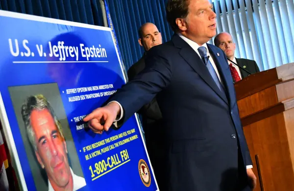 Geoffrey Berman, U.S. attorney for the Southern District of New York, speaks while standing next to a poster displaying the image of fund manager Jeffrey Epstein. (Louis Lanzano/Bloomberg)
