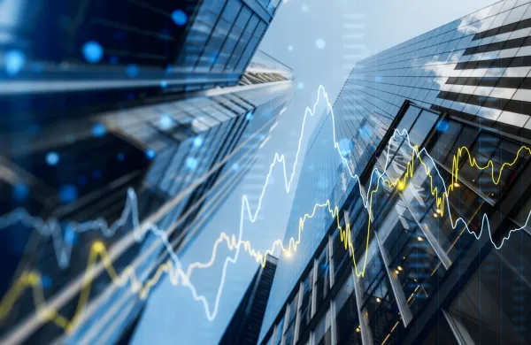 A double exposure image of skyscrapers with overlay of financial graphs, set against a blurred background, illustrating the concept of business growth