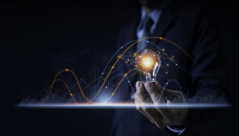 Businessman holding a light bulb showing ideas or investment planning, marketing strategy, has realistic graphs showing business growth Businessman holding a light bulb showing ideas or investment planning, marketing strategy, has realistic graphs showing business growth