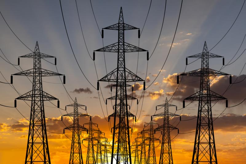 High voltage towers at sunset background. Power lines against the sky