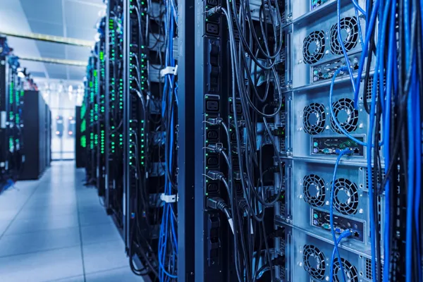 Server racks with blue and green cables in a data center.